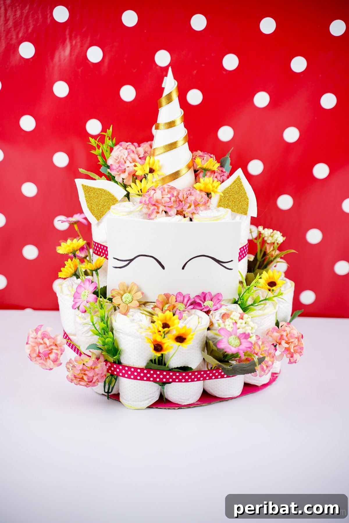 Create a Magical Unicorn Diaper Cake 25 Unicorn diaper cake in front of a cheerful red and white polka dot background