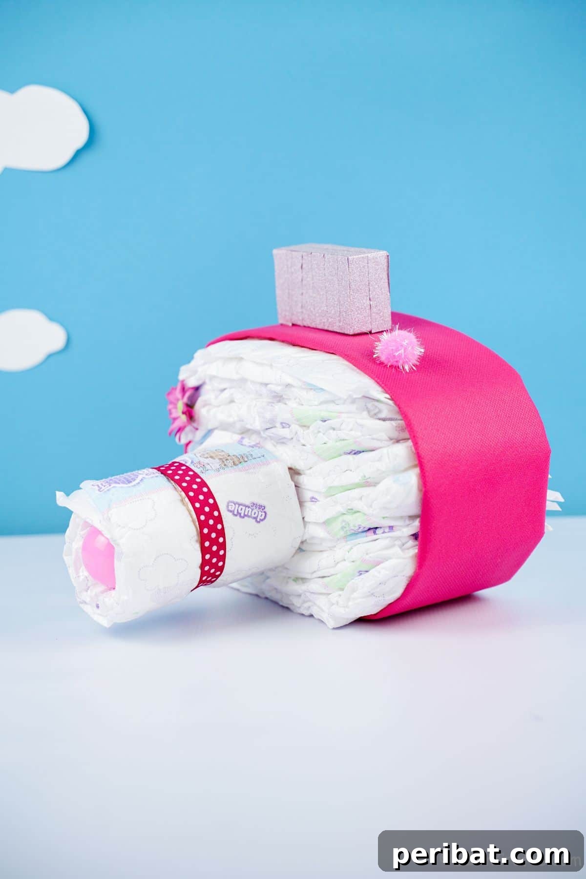 Picture Perfect Diaper Cake Camera 21 Close-up of a camera diaper cake on a white table with a vibrant blue background