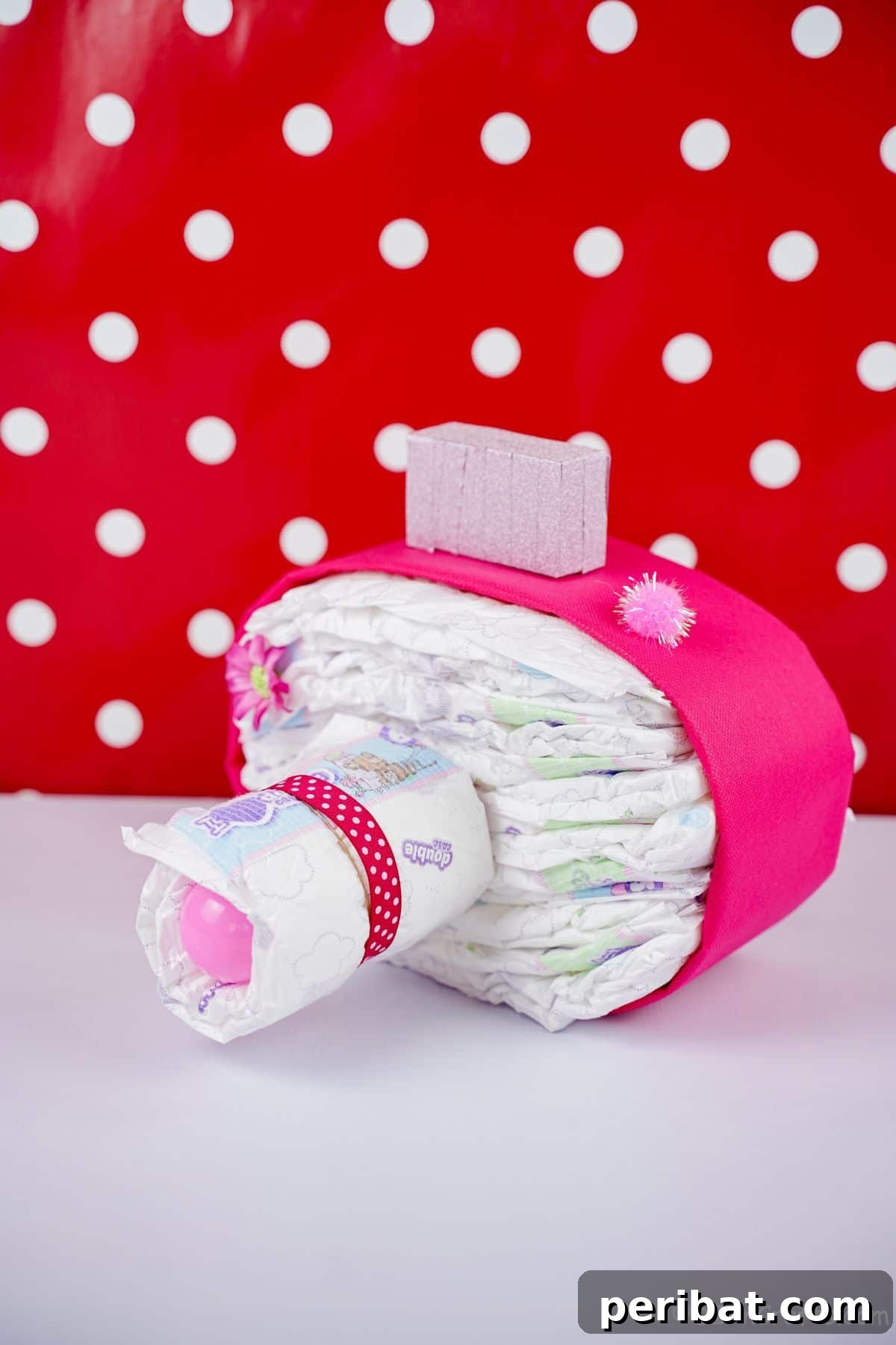 Picture Perfect Diaper Cake Camera 22 Stylish pink camera diaper cake against a cheerful red and white polka dot background