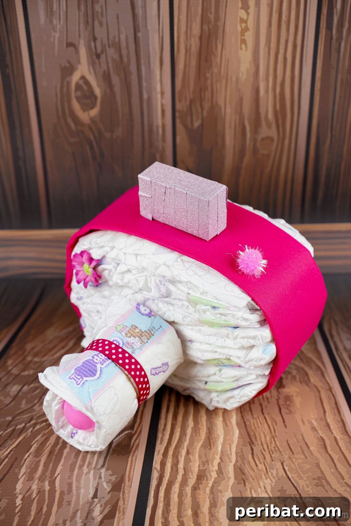 Picture Perfect Diaper Cake Camera 7 Pink camera diaper cake resting on a distressed wood paneling background