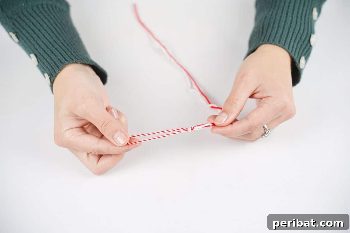hand tying red and white yarn together
