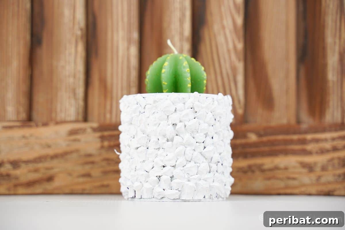 Nature-Inspired Upcycled Tin Can Planters 7 A beautifully upcycled tin can planter, holding a candle, placed on a white table against a warm wood background, showcasing its versatile charm.