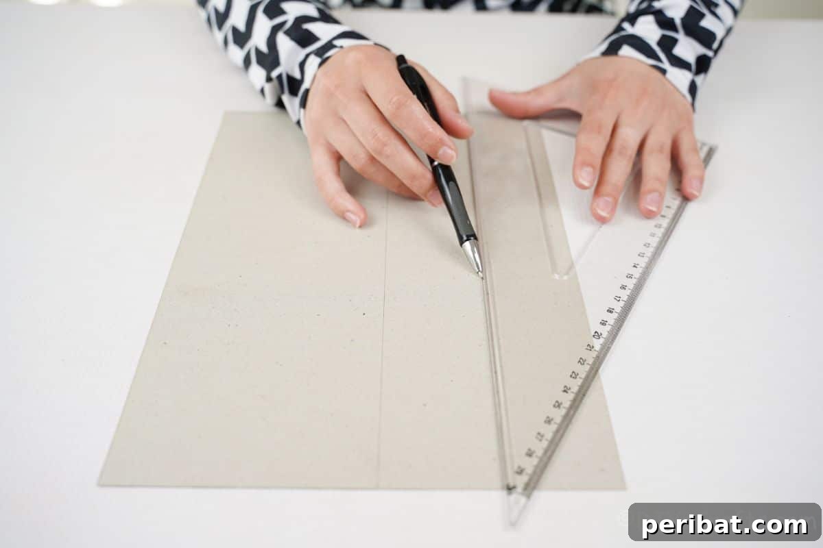 Charming Upcycled Tin Door Wreath 11 A hand uses a ruler and pen to measure and mark the back of a piece of scrapbook paper on a clean white table, indicating preparation for cutting.