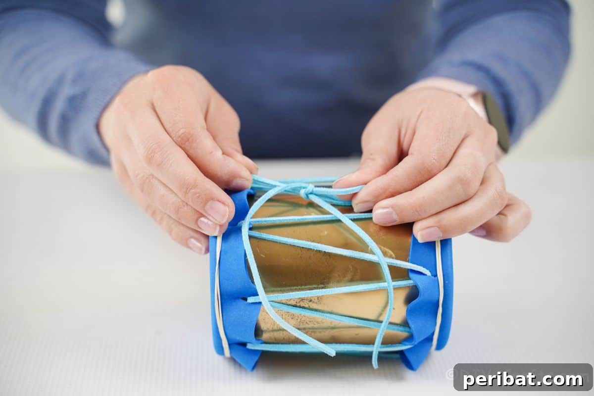 Percussion from the Pantry: Upcycled Tin Can Drums 13 hand tying blue leather ribbon on side of mini drum