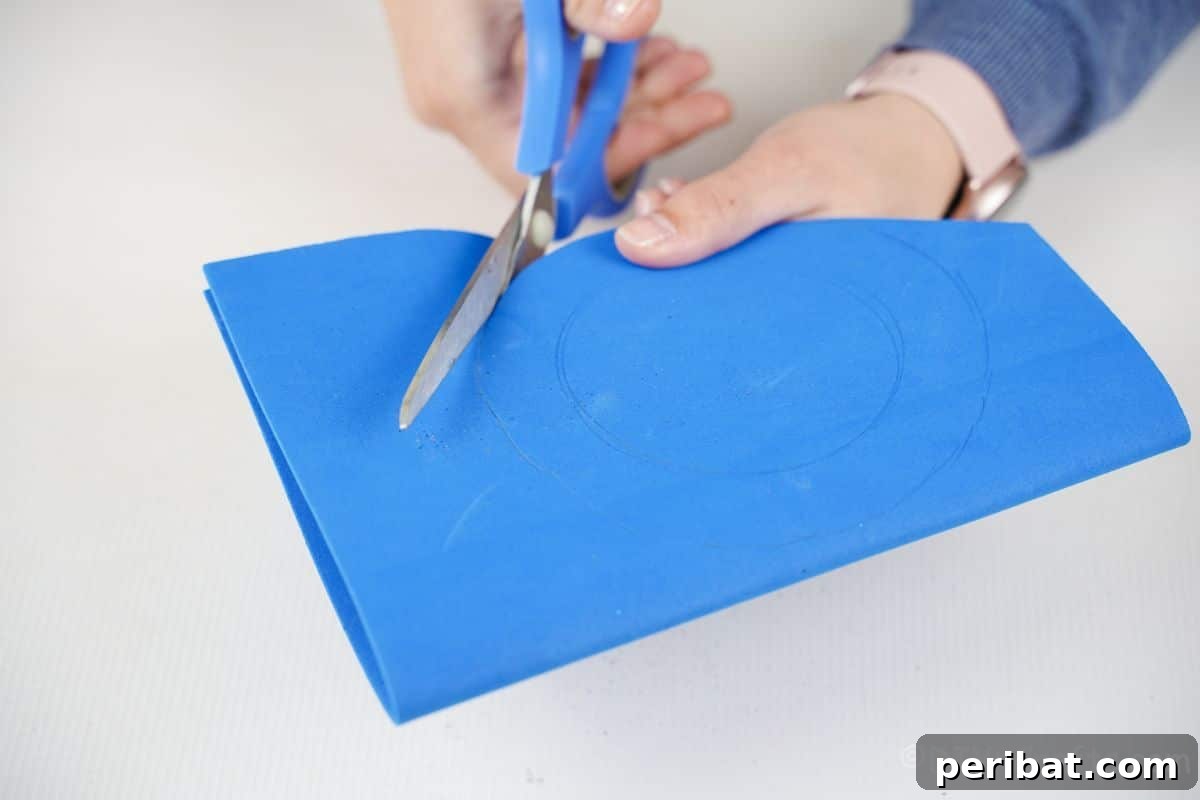 Percussion from the Pantry: Upcycled Tin Can Drums 9 hand holding blue scissors cutting blue foam paper circle