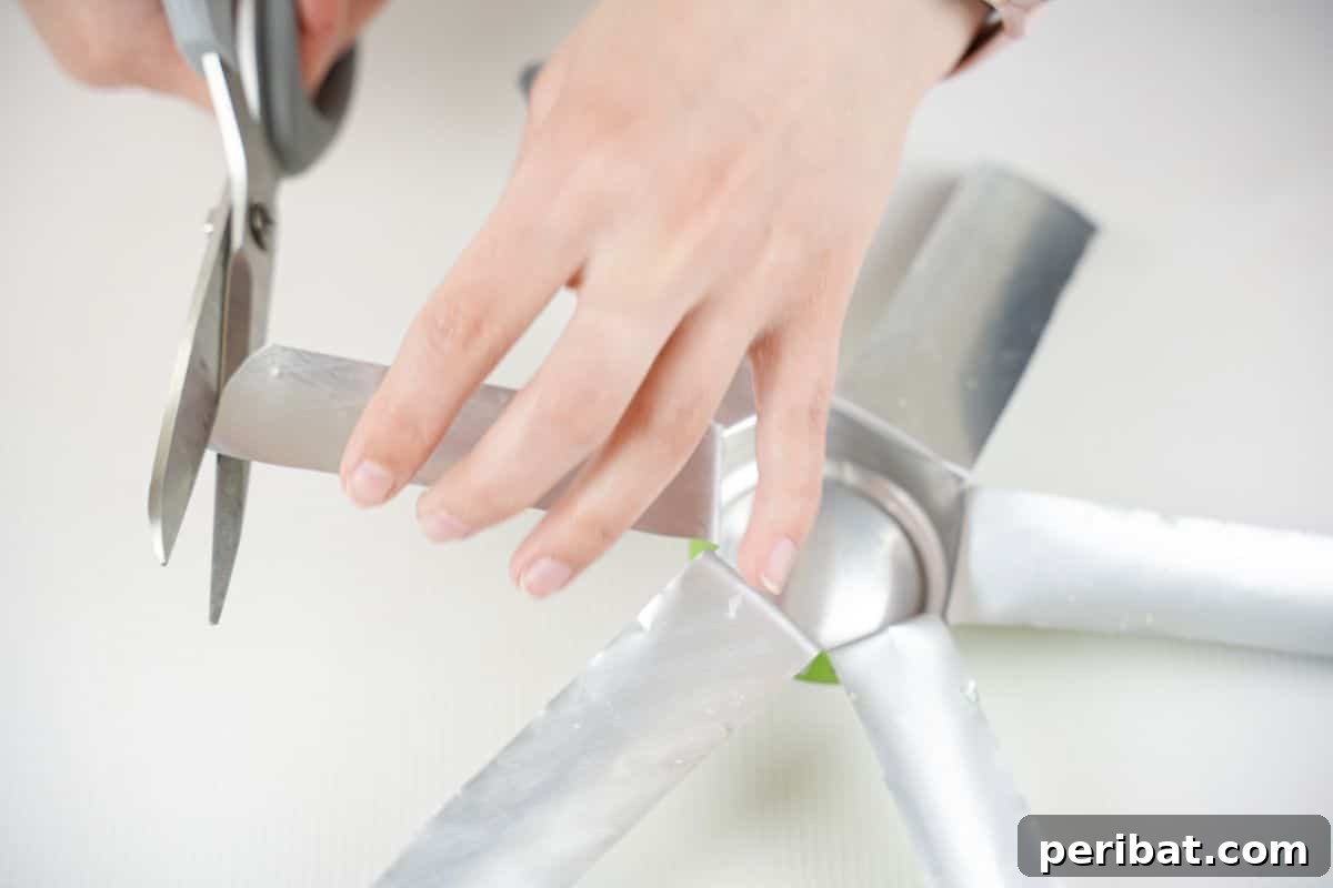 Aluminum Bloom Art 11 hand using gray scissors to trim edges off soft drink can