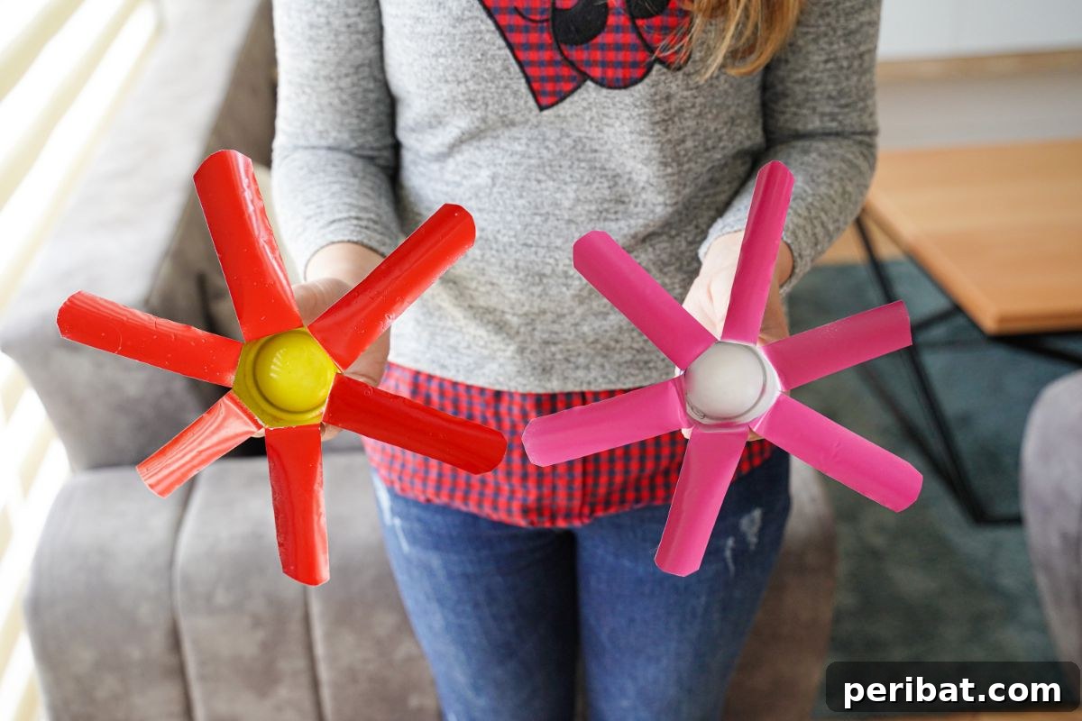 Aluminum Bloom Art 6 red and pink metal flowers held by woman in gray sweater