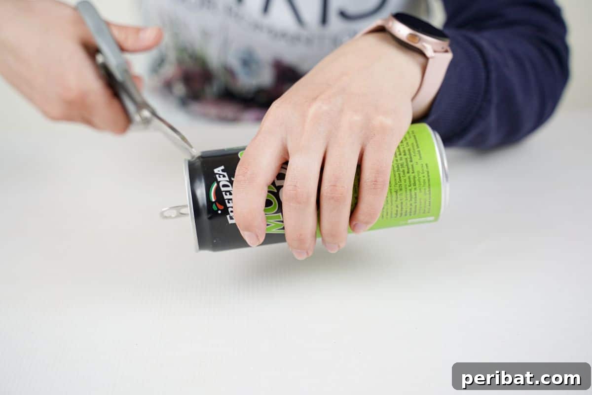 Aluminum Bloom Art 9 hand holding soda can while scissors cut end off