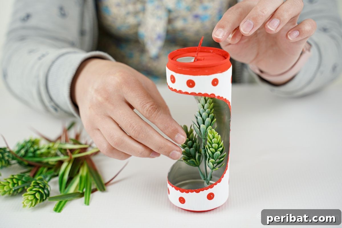 hand gluing fake greenery into soda can planter