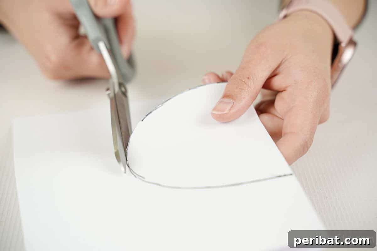 hand cutting white paper with gray scissors