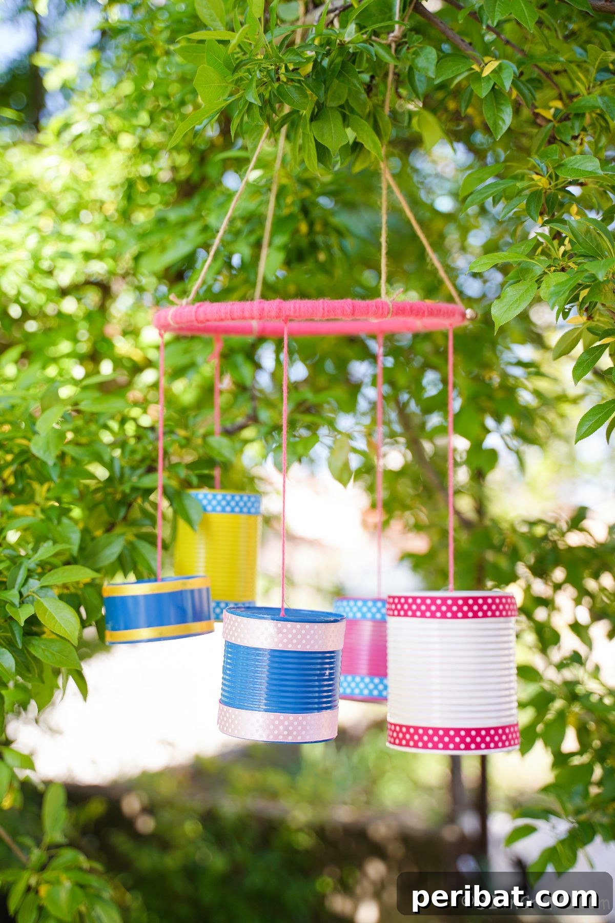 Another stunning view of the tin can wind chime, showcasing its vibrant array of colors and the various sizes of cans, all gracefully suspended in a lush green tree