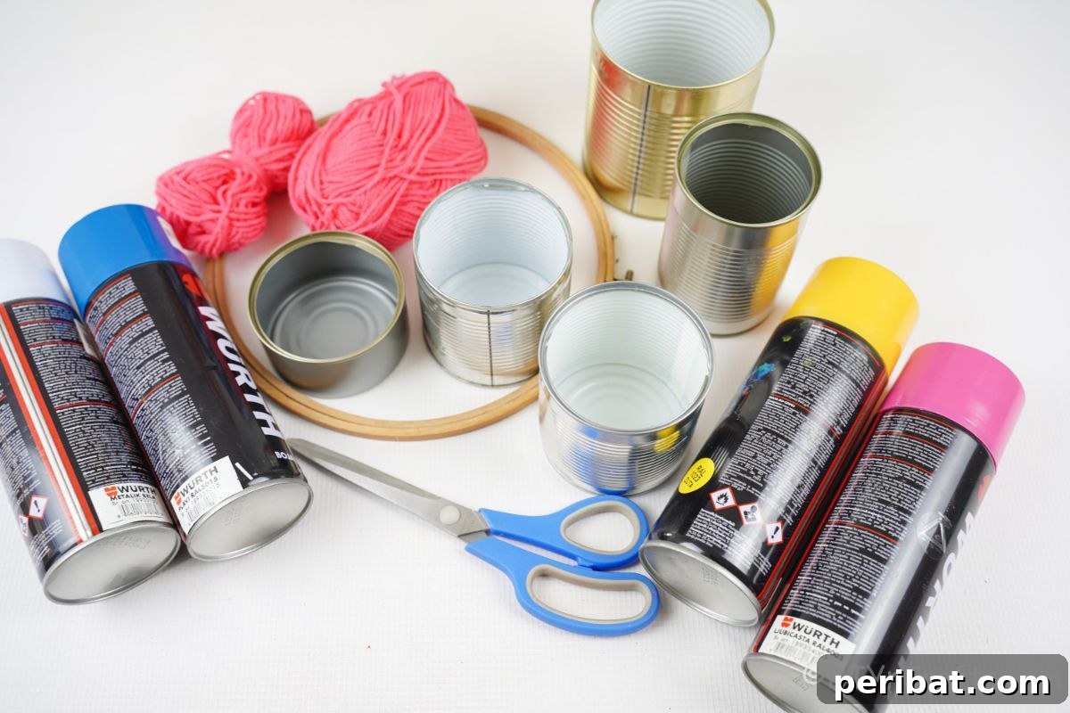 Transform Tin Cans into Melodious Wind Chimes 8 A neatly arranged collection of craft supplies, including various spray paint cans, an assortment of tin cans, an embroidery hoop, and yarn, all laid out on a clean white table