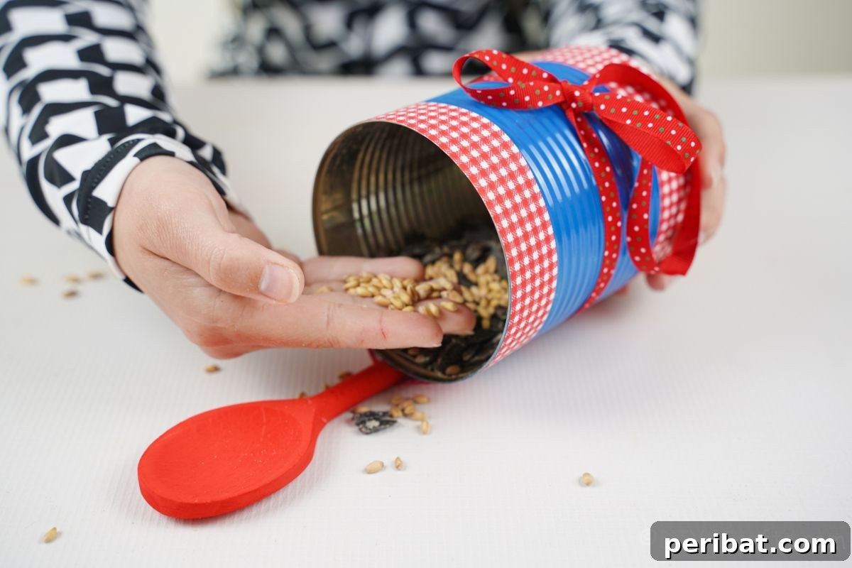 Sweet DIY Tin Can Bird Feeder 13 A hand carefully pours bird seed into the newly crafted tin can bird feeder, preparing it for its feathered guests.