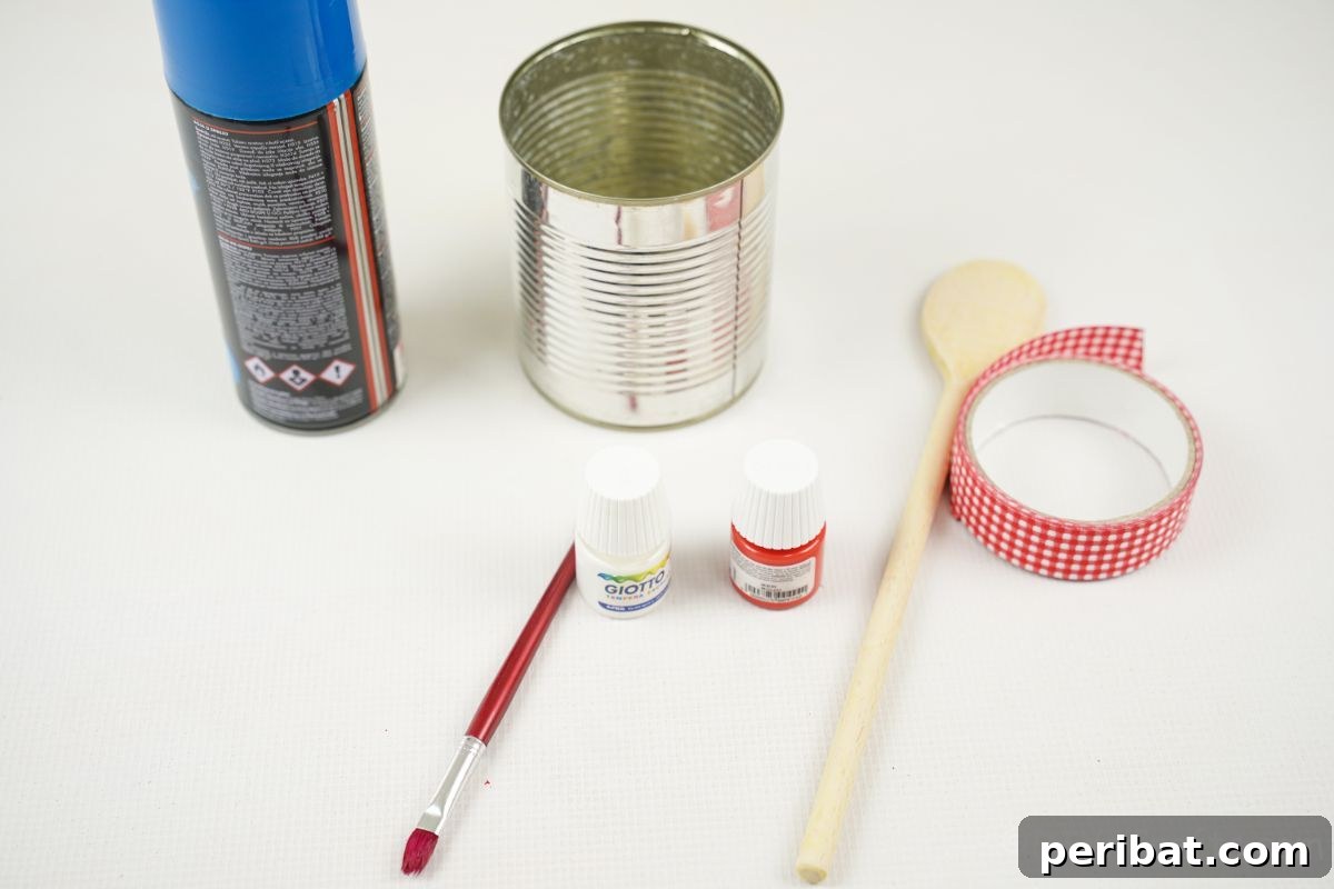 Sweet DIY Tin Can Bird Feeder 7 A curated display of crafting essentials: a tin can, blue spray paint, red ribbon, paint, and a wooden spoon, all neatly arranged on a white table.