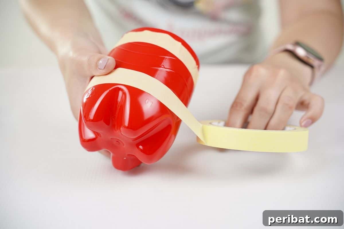 Upcycled Ladybug Garden Gems 15 masking tape being wrapped around red painted bottle