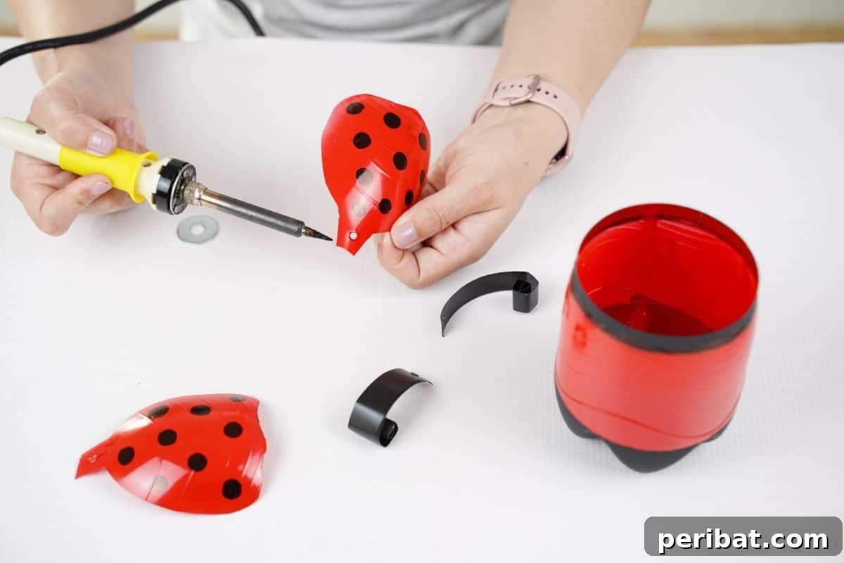Upcycled Ladybug Garden Gems 18 hand holding soldering iron making holes on wings