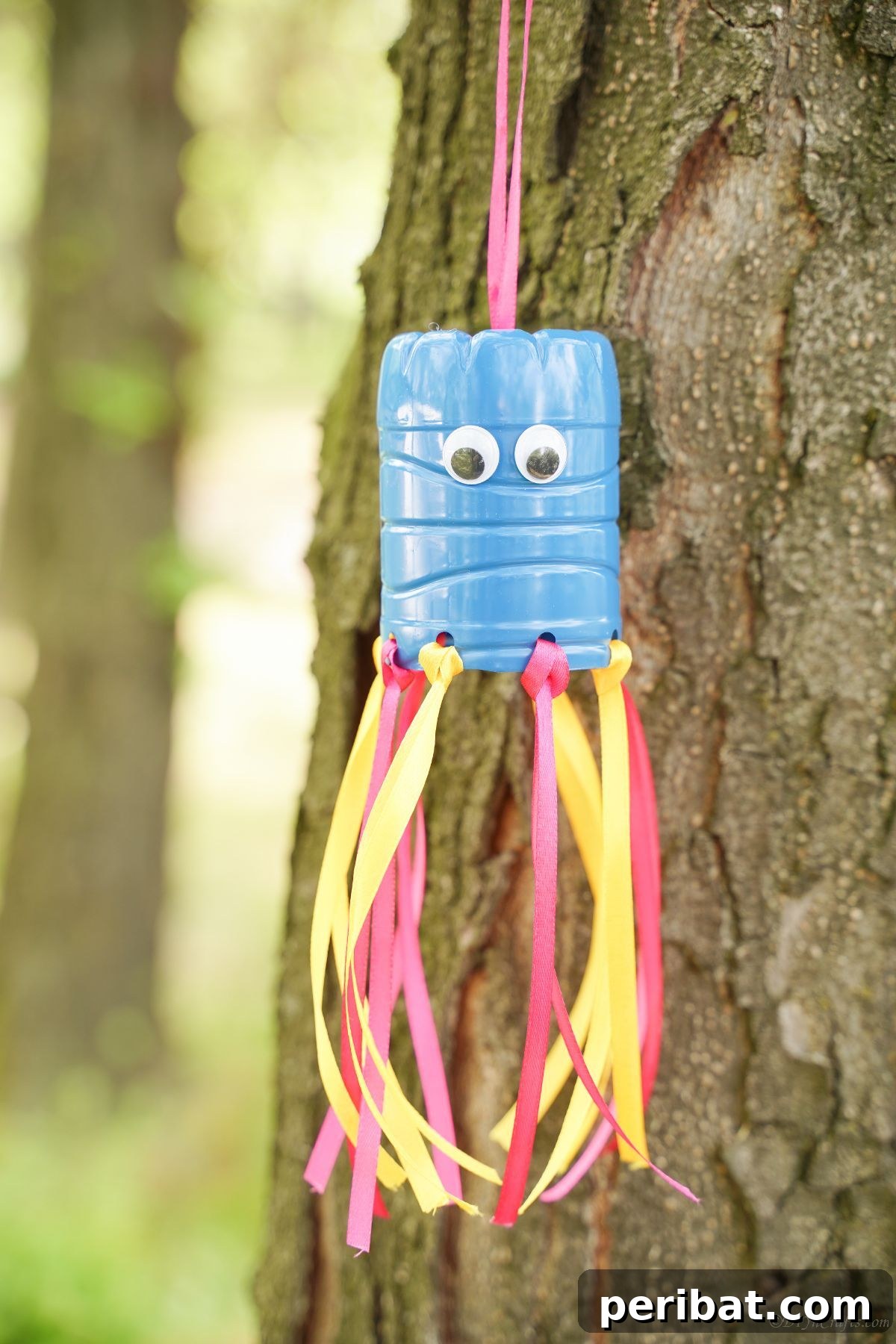 Vibrant Upcycled Bottle Wind Streamer 2 Smiling face on blue top of windsock with colorful ribbons