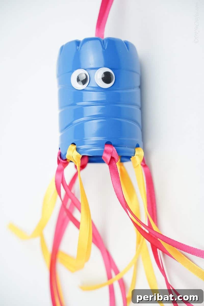 Vibrant Upcycled Bottle Wind Streamer 6 Close up of a blue top of windsock with yellow and pink ribbon base