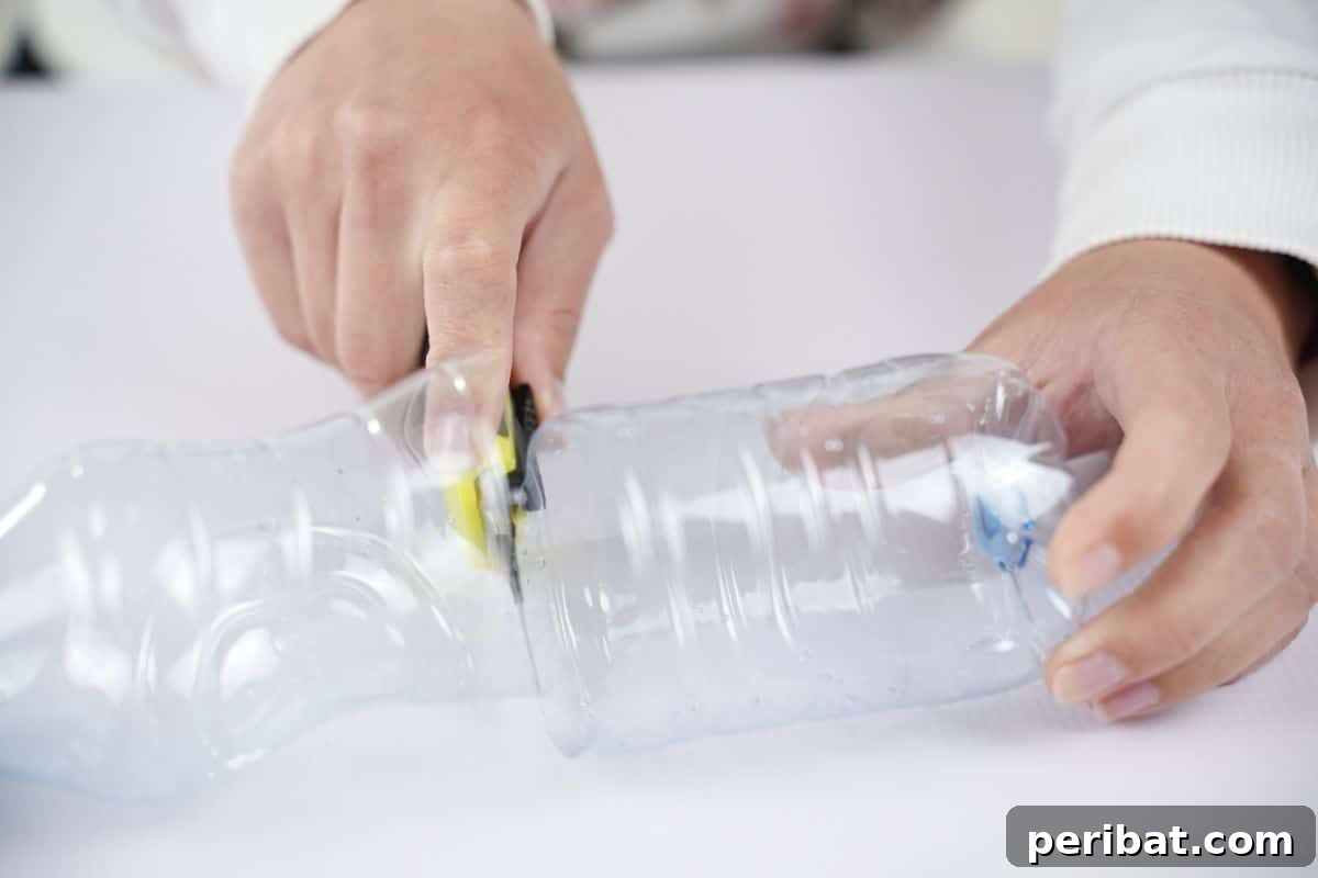 Vibrant Upcycled Bottle Wind Streamer 8 Hand cutting an empty plastic bottle in half with scissors
