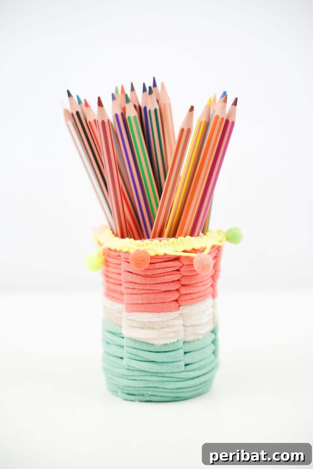 Upcycled Plastic Bottle Desk Organizer 4 Handcrafted pink, green, and white yarn-covered pencil holder, standing on a clean white table, ready for use.
