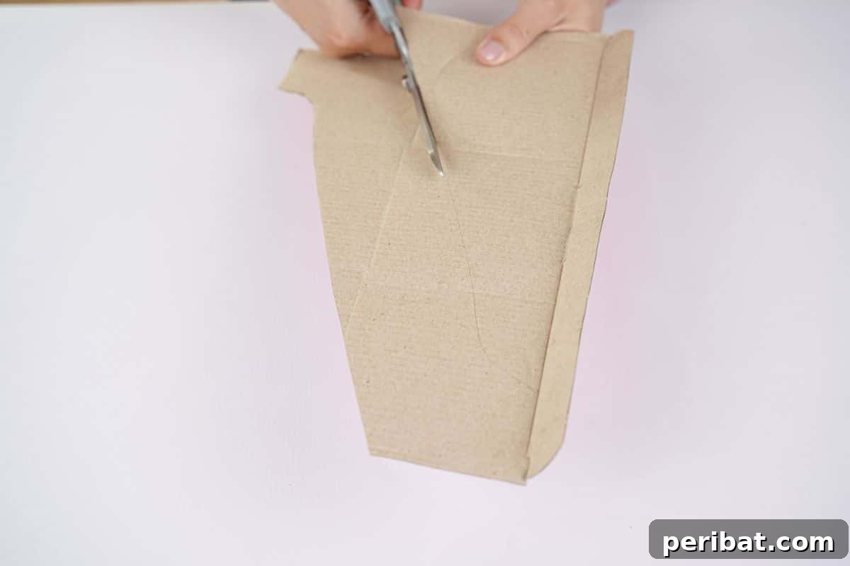 Blue scissors being used to cut cardboard for the airplane wings, ensuring symmetrical shapes.