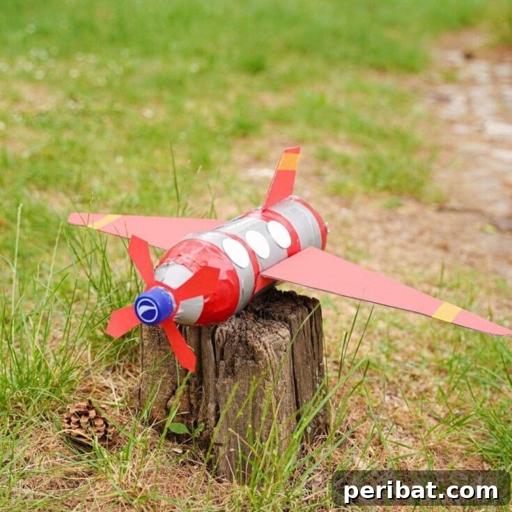 Upcycle Bottles Into Fun Toy Airplanes 7 Red plastic bottle airplane on stump, showcasing the finished craft.