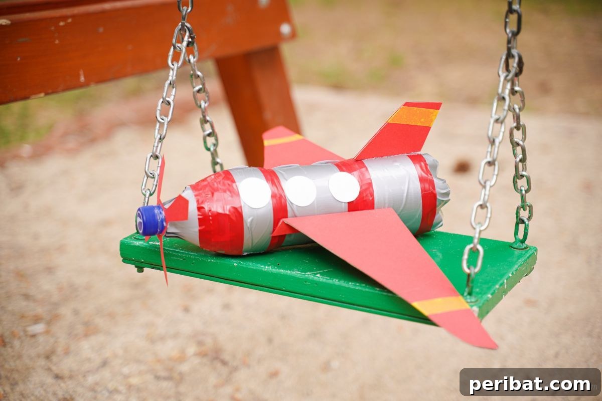 Upcycle Bottles Into Fun Toy Airplanes 5 A charming toy airplane, crafted from a plastic bottle, rests on a swingset, ready for imaginative play.