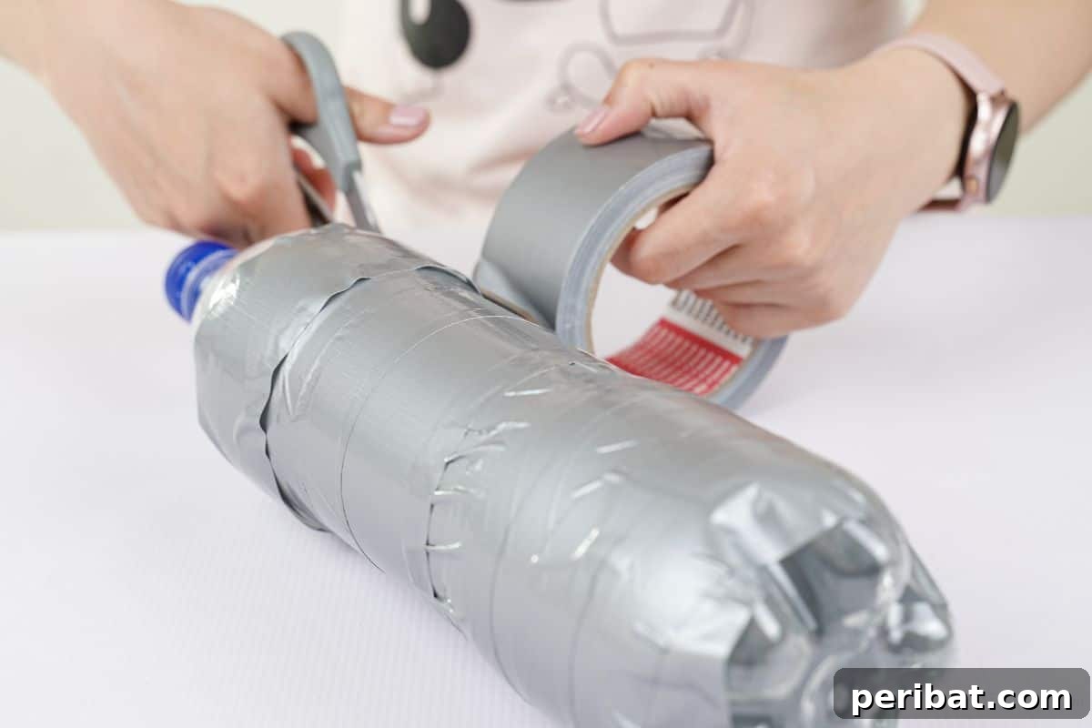 Upcycle Bottles Into Fun Toy Airplanes 8 Hands holding gray scissors to cut end of duct tape on bottle, showing the initial step of wrapping the bottle.