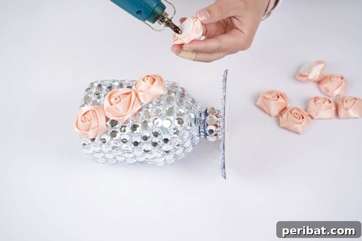 Radiant Recycled Rhinestone Vase 13 hand adding pink roses on side of plastic bottle vase