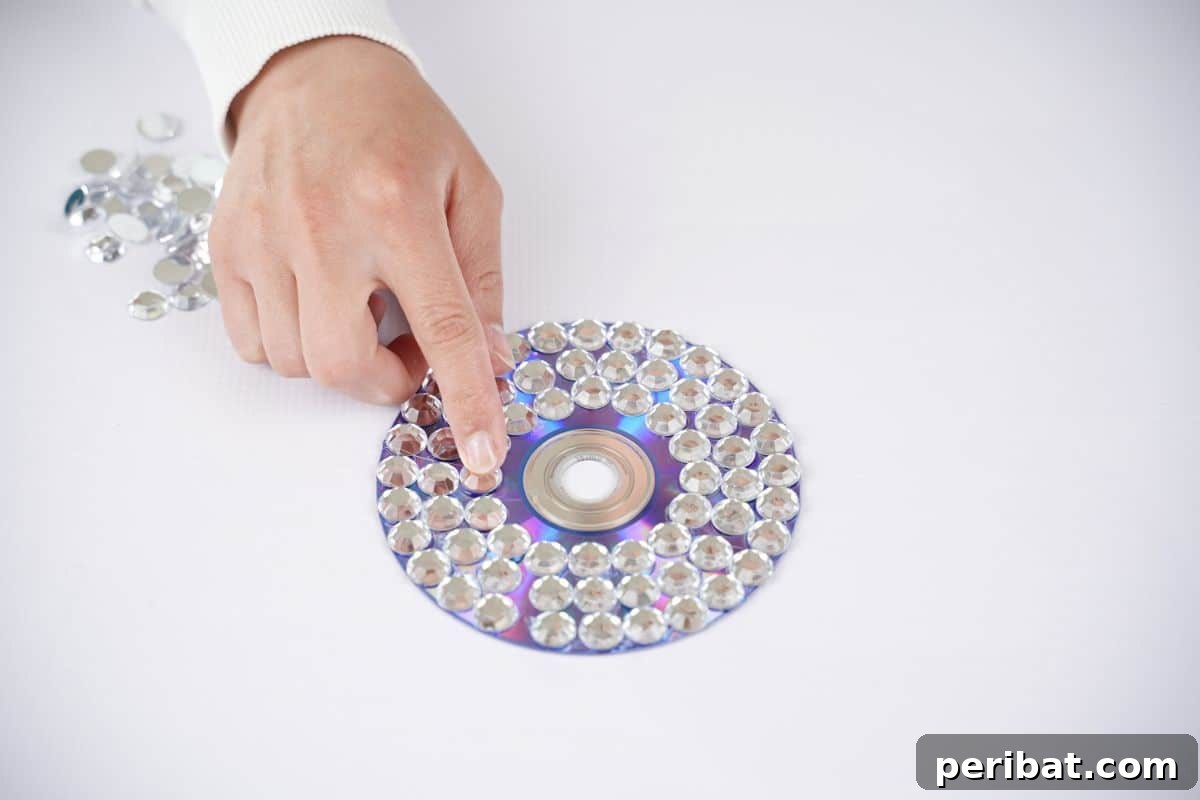 Radiant Recycled Rhinestone Vase 17 hand holding rhinestones on top of cd