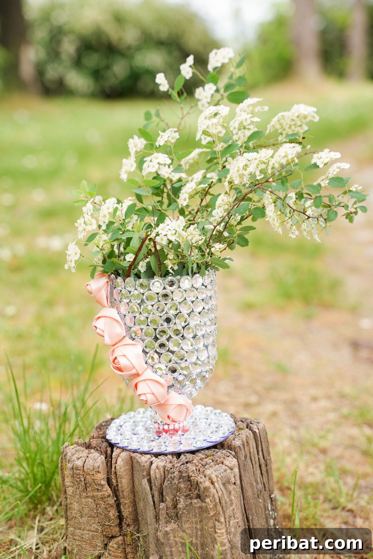 Radiant Recycled Rhinestone Vase 4 white flowers and greenery in vase on top of tree stump