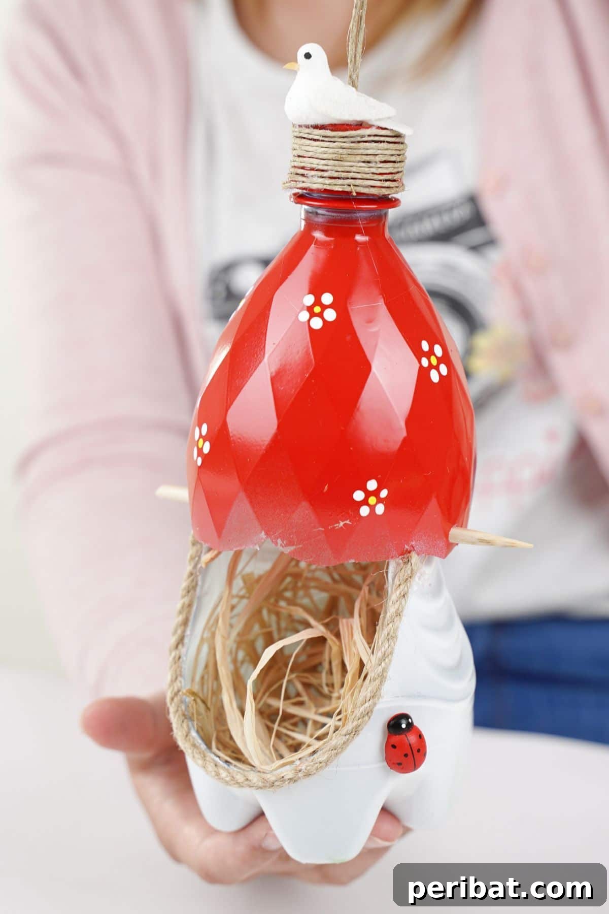 Upcycled Bottle Birdhouse 28 hands holding red and white birds nest