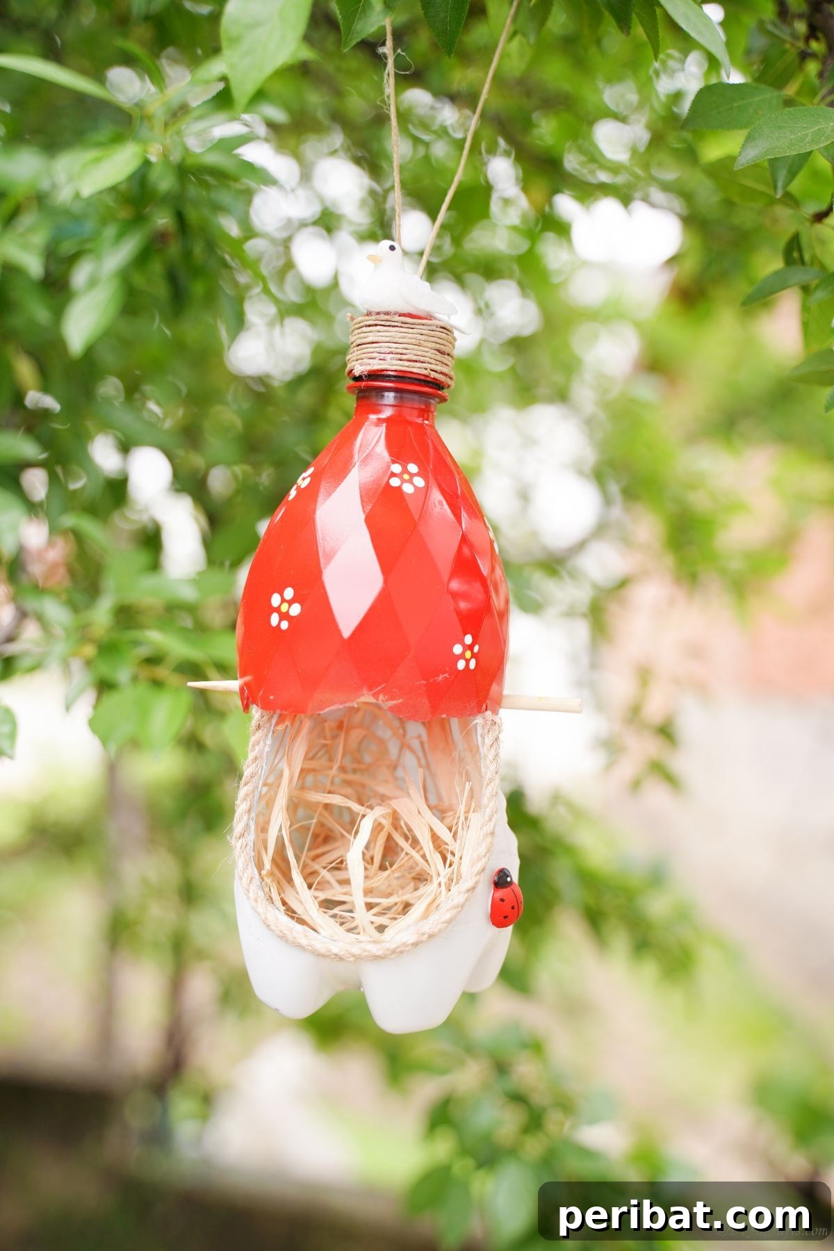 Upcycled Bottle Birdhouse 19 Bird nest made of plastic bottle hanging gracefully among natural tree branches