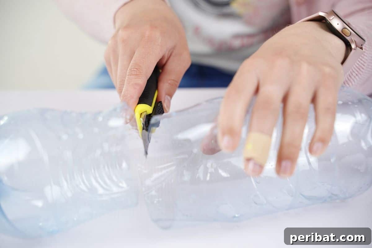 Upcycled Bottle Birdhouse 7 Craft knife carefully cutting the middle section of a plastic bottle, leaving only the base