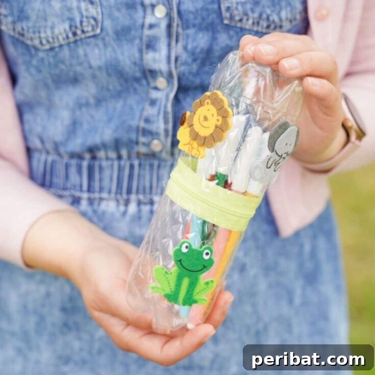 Woman holding a finished plastic bottle pencil case adorned with a lion sticker, demonstrating a simple, no-sew craft.