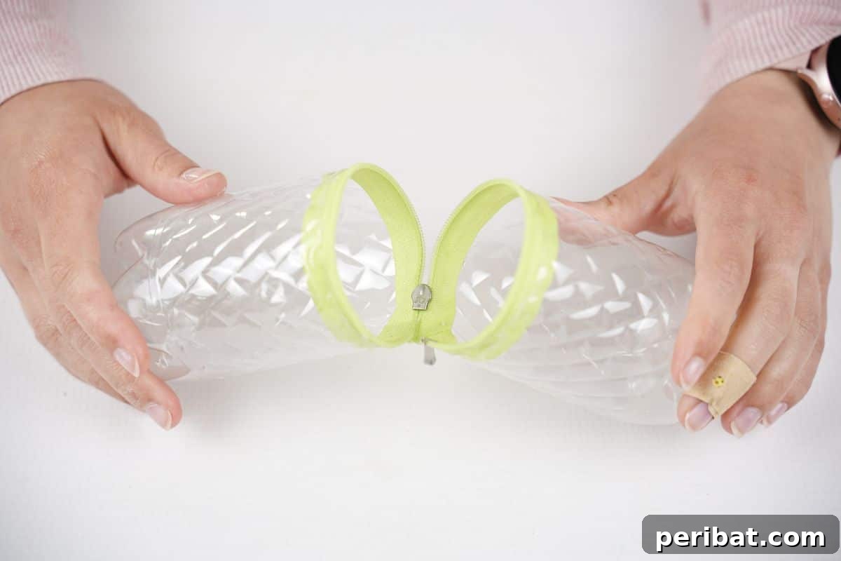 Stitch-Free Upcycled Bottle Stationery Pouch 16 Hands holding open the newly crafted plastic bottle pencil case, showing its interior capacity.