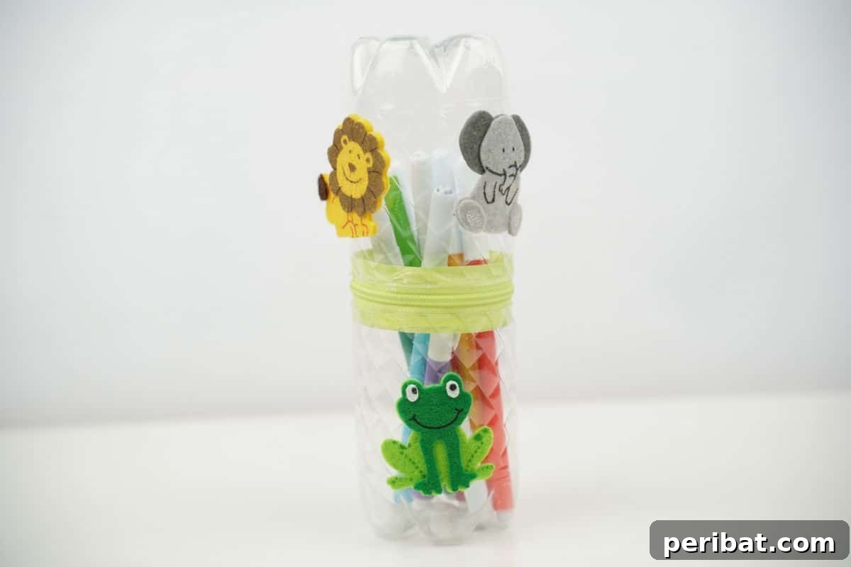 Stitch-Free Upcycled Bottle Stationery Pouch 20 A beautifully decorated no-sew pencil case made from a plastic bottle, displayed on a pristine white table.