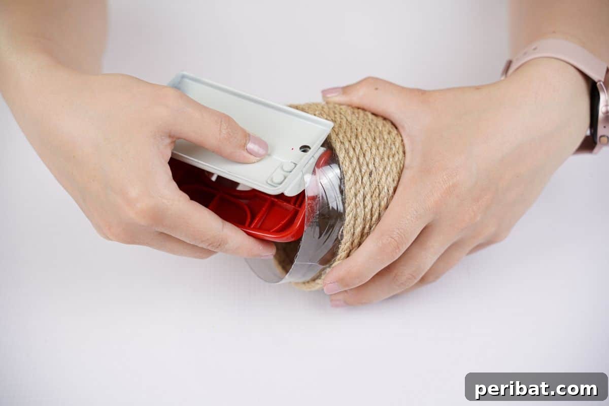 DIY Rustik İp Sarılı Şişe Bahçe Planterları 11 A hole punch being skillfully used on the side of a plastic bottle, creating an attachment point for the hanging planter.