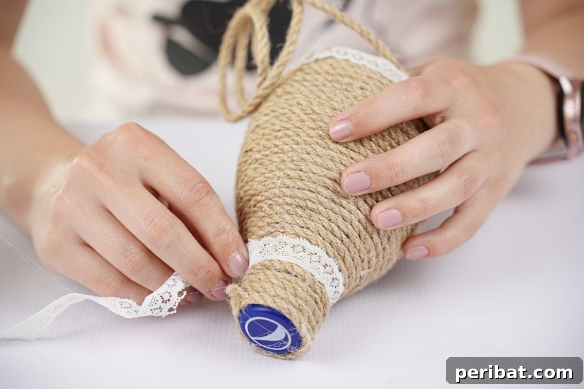 DIY Rustik İp Sarılı Şişe Bahçe Planterları 14 Lace ribbon being carefully wrapped around the neck of a twine-wrapped water bottle, adding an elegant detail to the DIY planter.