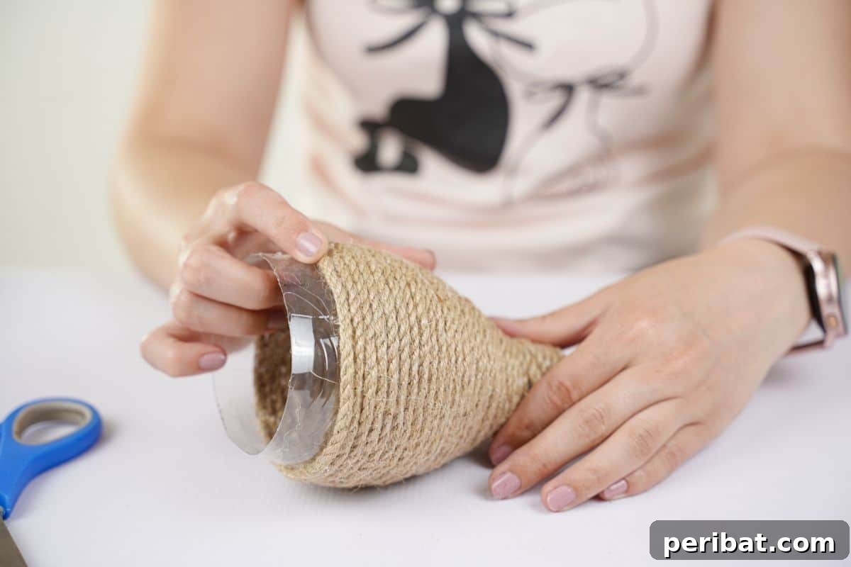 DIY Rustik İp Sarılı Şişe Bahçe Planterları 10 Twine being carefully glued onto a water bottle in progress, illustrating the wrapping technique for the DIY planter.