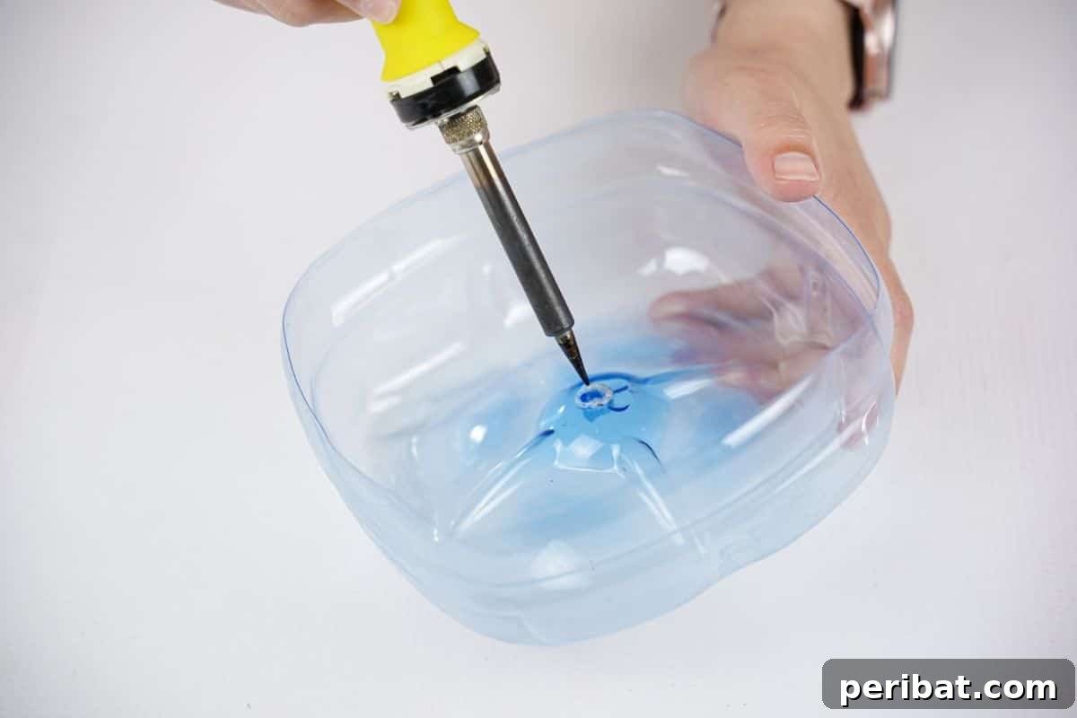 Recycled Bottle Bird Retreat 8 a soldering iron being used to create a precise hole in the center of a plastic bottle base