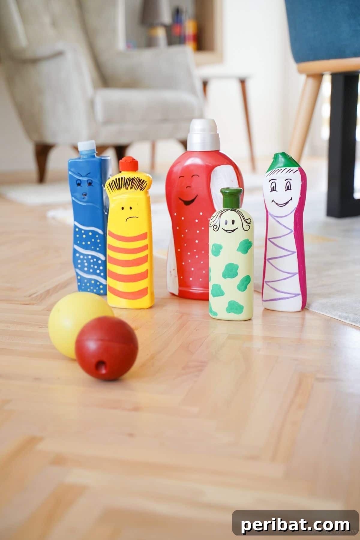 Craft Upcycled Bottle Characters for a DIY Bowling Game 2 Colorful painted plastic bottles arranged on a wooden table with small colorful balls, ready for a fun activity.
