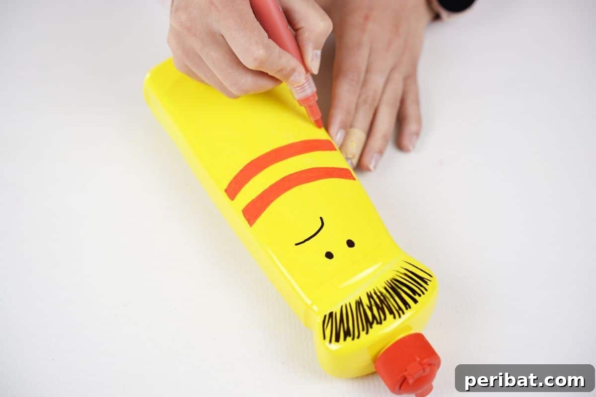 Craft Upcycled Bottle Characters for a DIY Bowling Game 15 Red stripes being meticulously drawn onto a yellow painted plastic bottle, adding vibrant details to the character's design.