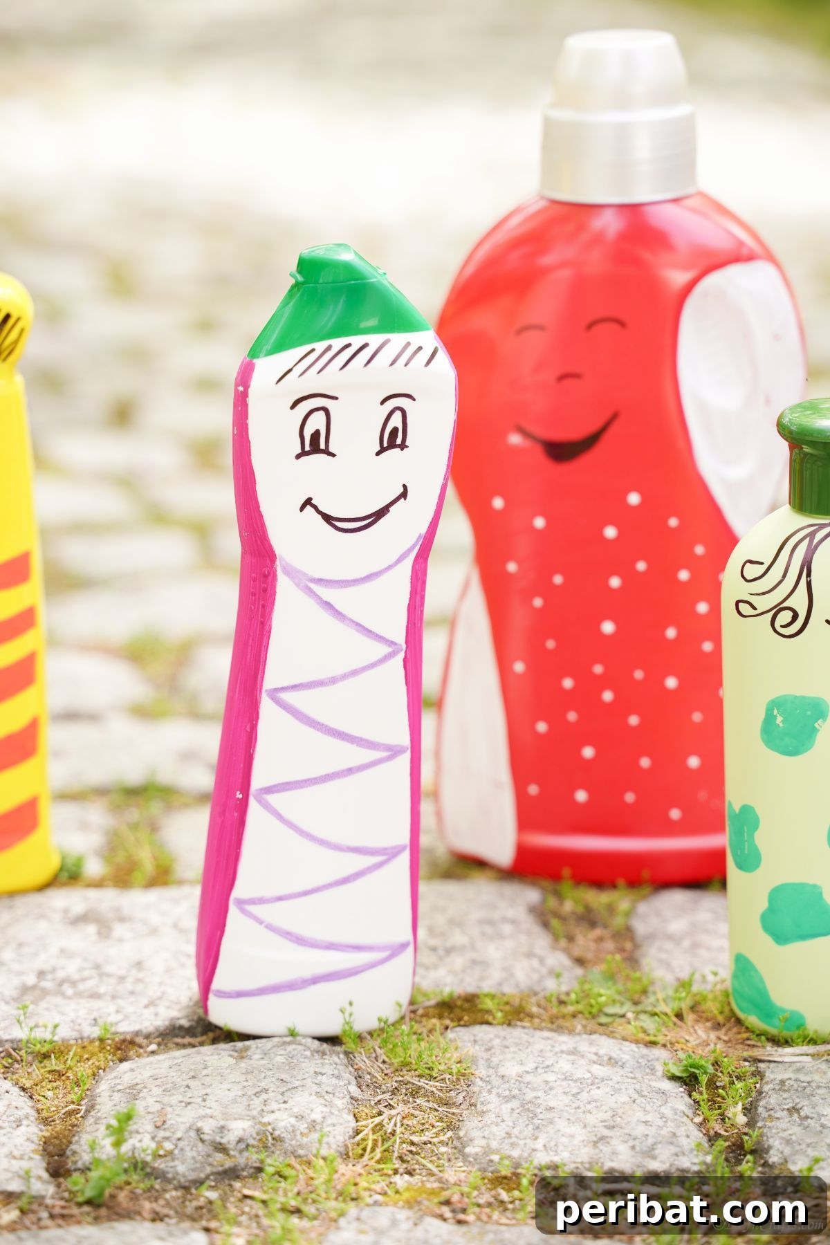 Craft Upcycled Bottle Characters for a DIY Bowling Game 5 A group of painted plastic bottle character puppets standing on a textured rock pathway, ready for play.