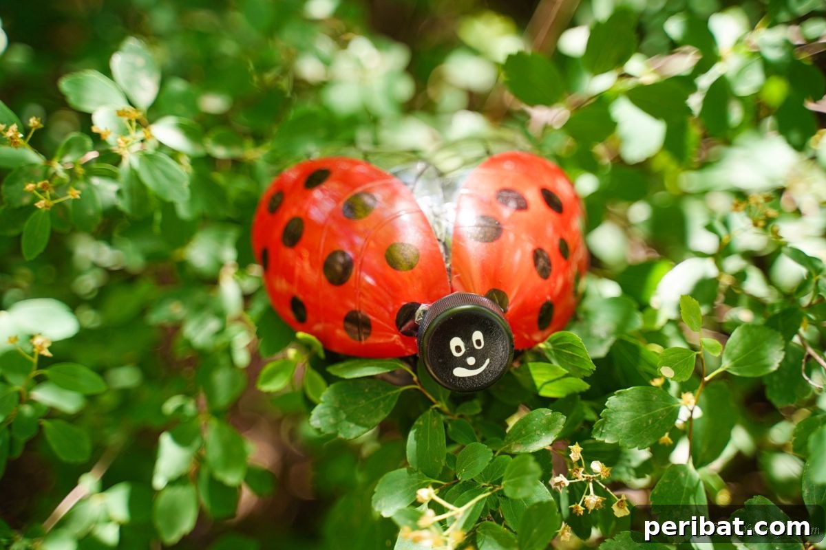 Charming Ladybug Garden Decor from Upcycled Bottles 19 A vibrant red and black plastic bottle ladybug decoration perched in a tree, adding a whimsical touch to the foliage.