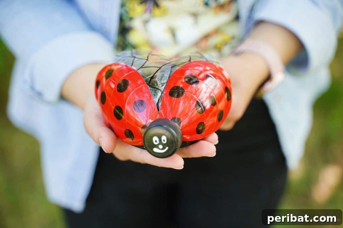 Charming Ladybug Garden Decor from Upcycled Bottles 3 A pair of hands gently holding a freshly crafted plastic bottle ladybug decoration, demonstrating the finished product.