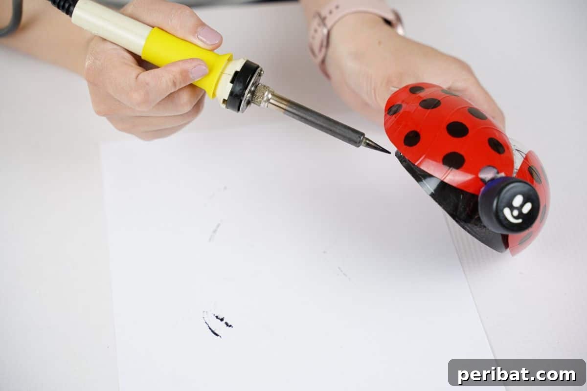 Charming Ladybug Garden Decor from Upcycled Bottles 26 soldering iron held against ladybug decoration