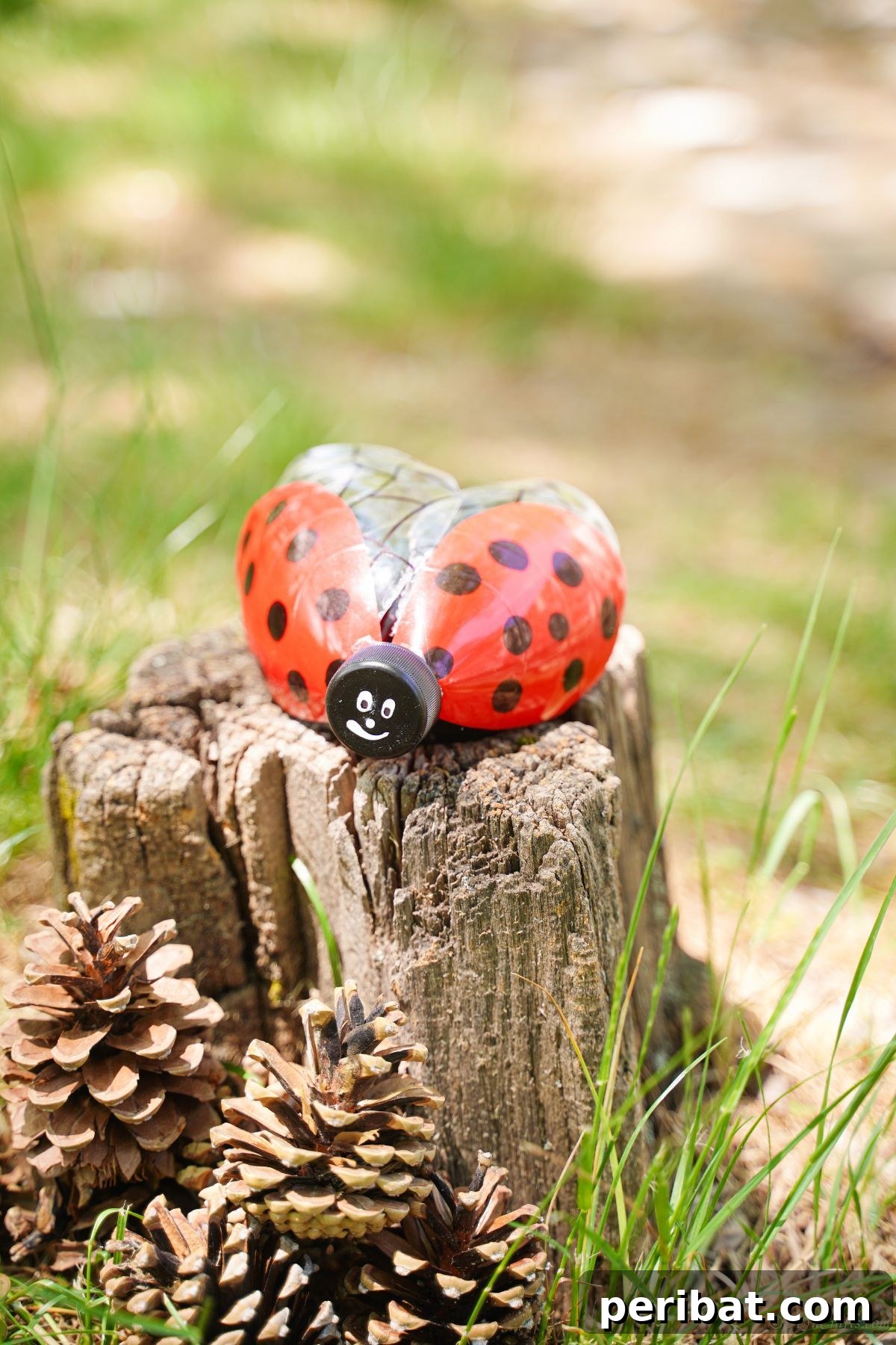 Charming Ladybug Garden Decor from Upcycled Bottles 5 A beautifully painted plastic bottle ladybug decoration positioned on a tree stump, adding a pop of color to the natural setting.