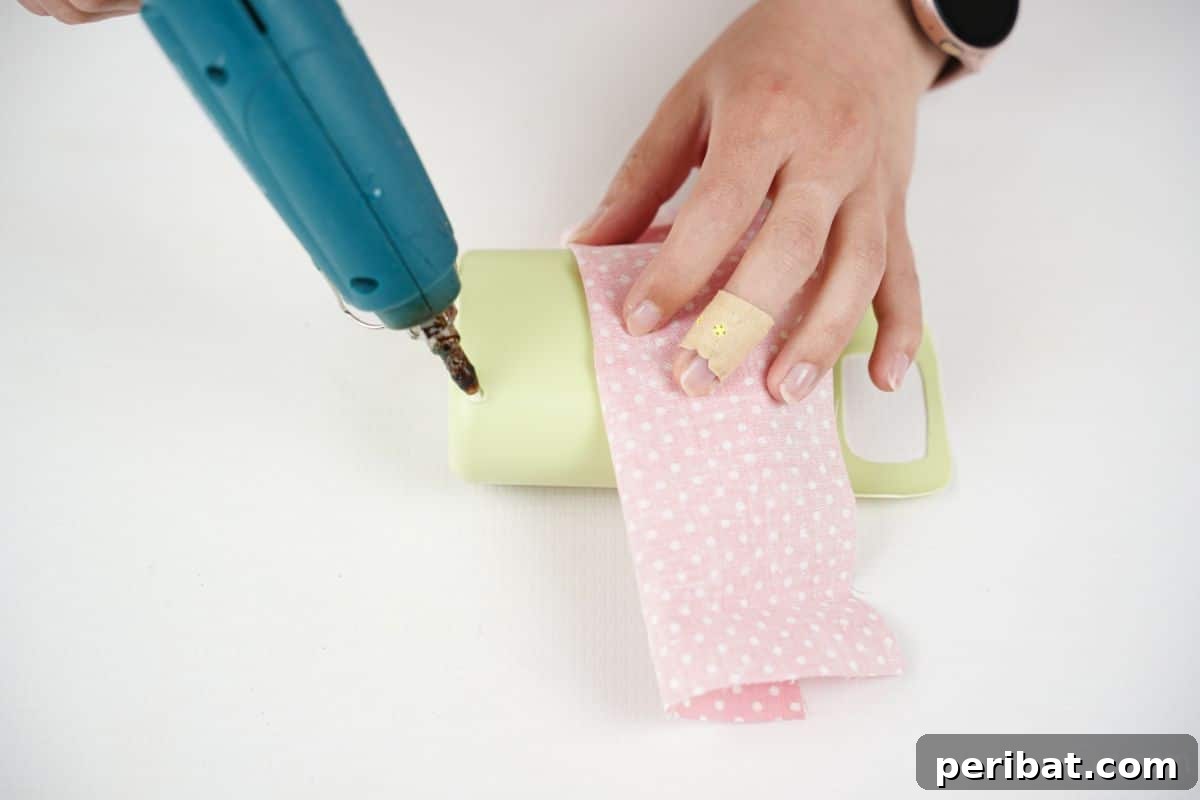 glue being put on green bottle with pink fabric