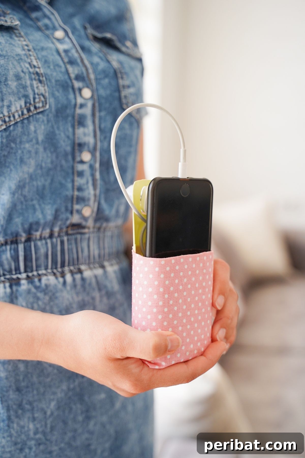 woman in denim holding pink and white cellphone holder